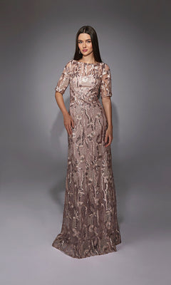 A woman stands against a plain gray background wearing the Alyce 27819 long formal dress, a floor-length mauve gown with short sleeves, embellished patterns, and intricate sequin and lace detailing.