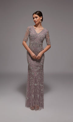 A woman models the Alyce 27824 long formal dress in mauve, featuring half sleeves, a V-neckline, and intricate beaded embroidery—an elegant choice for formal events—posed against a plain gray background.