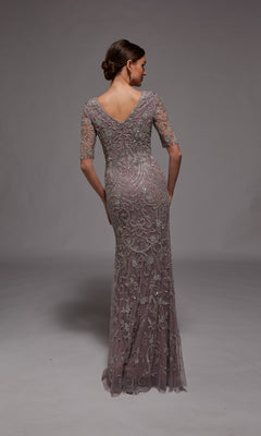 A woman stands with her back to the camera, wearing the Alyce 27824 long formal dress in mauve, featuring floor-length beaded embroidery and lace, elbow-length sleeves, and a V-shaped back—ideal for formal occasions.