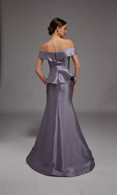 A woman stands facing away, wearing the Alyce 27827 long formal dress—a fitted, off-the-shoulder lavender mermaid gown with a peplum detail and smooth satin finish.