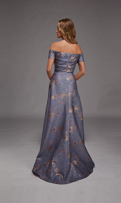 A woman faces away from the camera, highlighting the off-the-shoulder Alyce 27828 long formal dress in metallic blue jacquard with elegant floral patterns, set against a simple gray background.