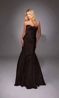 A woman wearing the Alyce 27836 long formal dress, featuring a strapless sweetheart neckline and fitted mermaid skirt, stands against a softly lit plain background.