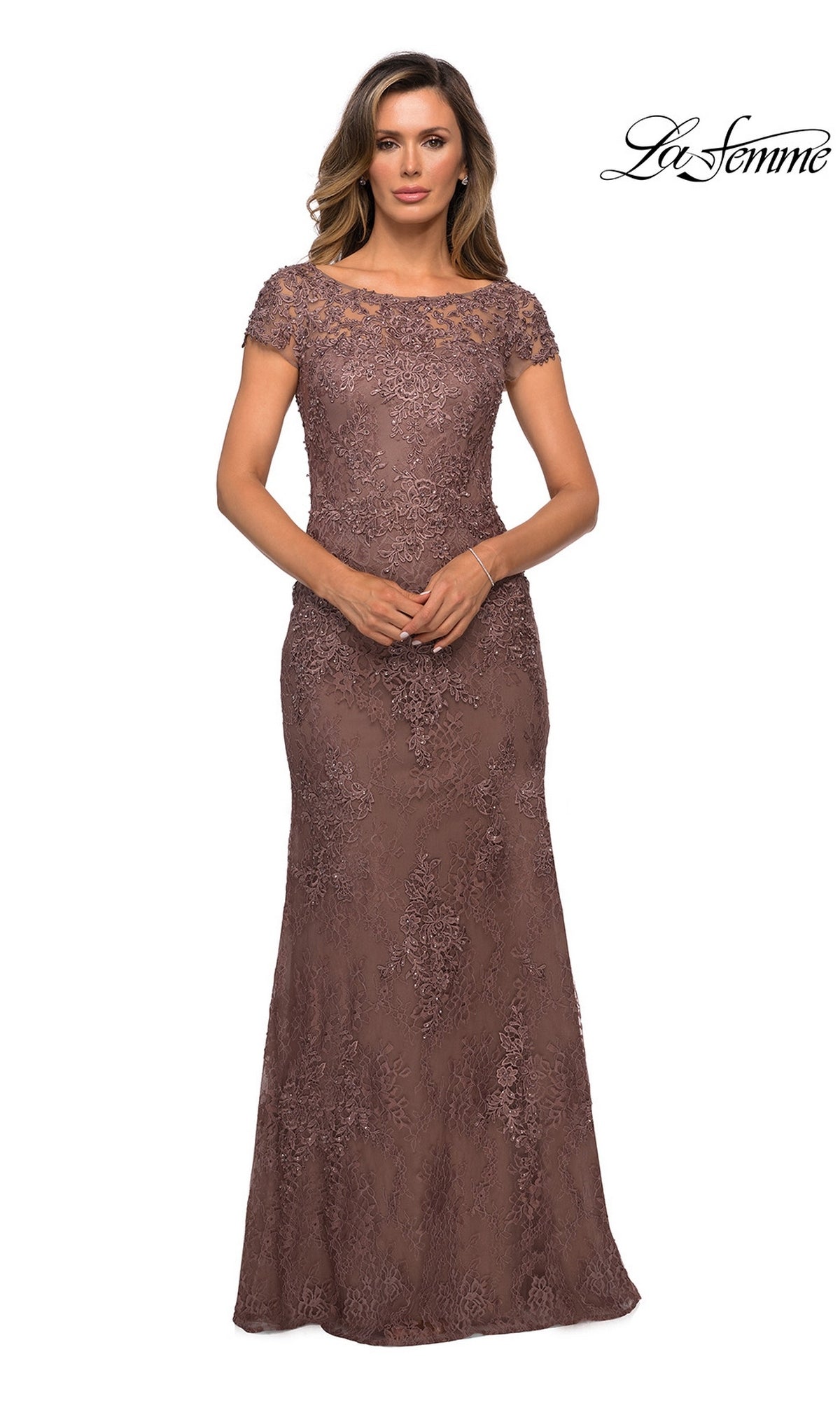A woman wearing a mocha La Femme 27856 floor-length lace sheath evening gown with cap sleeves and an illusion neckline.