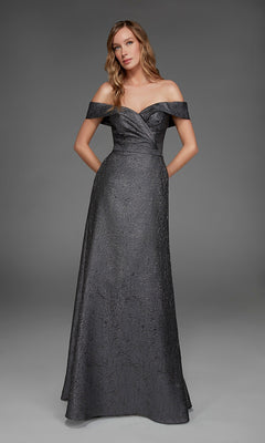 A woman stands in a studio wearing the Long Formal Dress: Alyce 27882—a floor-length, dark metallic jacquard evening gown featuring textured fabric and discreet pockets.