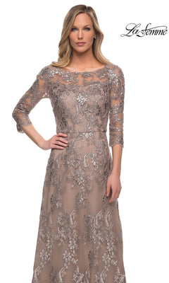 A woman wearing a La Femme 27885 long formal dress, a modest, taupe, A-line gown with three-quarter sleeves and an intricate silver floral lace overlay.