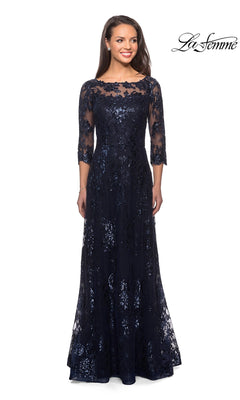 A woman wears a navy blue La Femme 27885 long formal dress with an A-line skirt, three-quarter sleeves, sequin-lace detailing, and an illusion neckline.