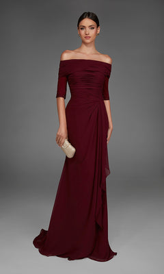 A woman wearing the Long Formal Dress: Alyce 27888 in burgundy holds a textured gold clutch while standing against a neutral gray background.