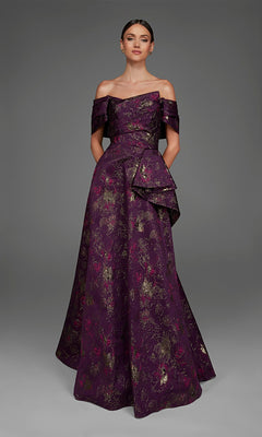 A woman wearing the Long Formal Dress: Alyce 27893 in a rich eggplant hue, featuring elegant off-the-shoulder straps and a luxurious purple and gold floral jacquard pattern, stands against a plain gray background.