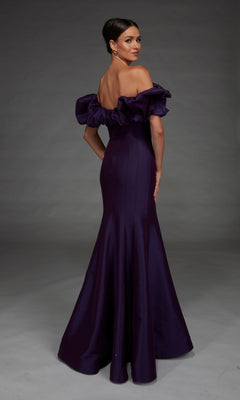 A woman poses with her back slightly turned, glancing over her shoulder, wearing the Alyce 27895 long formal dress—an off-the-shoulder, floor-length gown in deep purple taffeta featuring a graceful mermaid skirt—set against a plain dark gray background.