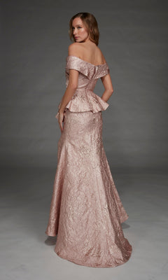 A woman stands against a plain gray background, looking over her shoulder while wearing the Alyce 27899 long formal dress—an off-the-shoulder, textured blush pink gown featuring a peplum waist.