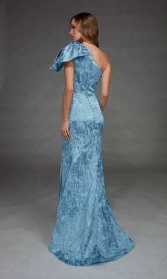 A woman is seen from the back in a studio, wearing the Alyce 27906 long formal dress—a light blue, floor-length gown with a textured fabric and a one-shoulder neckline.