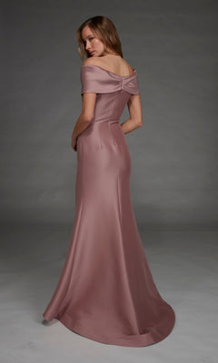 A woman stands against a plain gray background wearing the Long Formal Dress: Alyce 27908, a floor-length gown in mauve satin stretch mikado featuring off-the-shoulder sleeves and a bow detail on the back.
