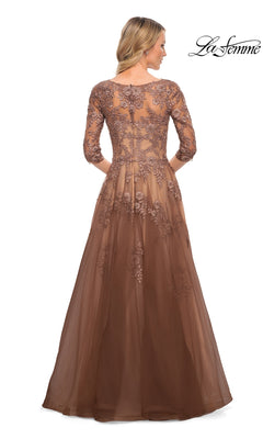 A woman wears a brown lace Long Formal Dress: La Femme 27908 with three-quarter sleeves and floral embroidery over a sheer bodice.