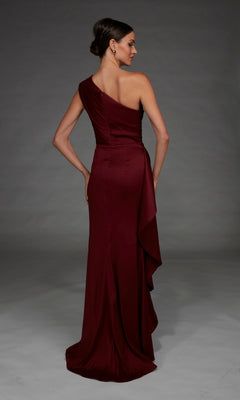 A woman wearing the Alyce 27913 long formal dress, a satin, floor-length, one-shoulder maroon gown, stands facing away with her hair styled in a low bun against a plain gray background.