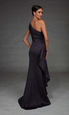A woman wearing the Long Formal Dress: Alyce 27913, featuring a sleek silhouette with a one-shoulder neckline, fitted bodice, elegant satin fabric, and draped detailing, stands against a plain gray background.