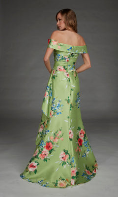 Wearing the Alyce 27915 long formal dress, a woman stands facing away against a plain gray background. The floor-length satin gown features an off-the-shoulder design with a green floral print.