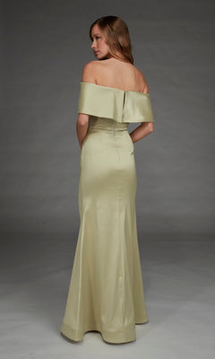 A woman stands with her back to the camera against a plain studio backdrop, wearing the Alyce 27916—a floor-length, off-the-shoulder long formal dress in light gold stretch mikado.