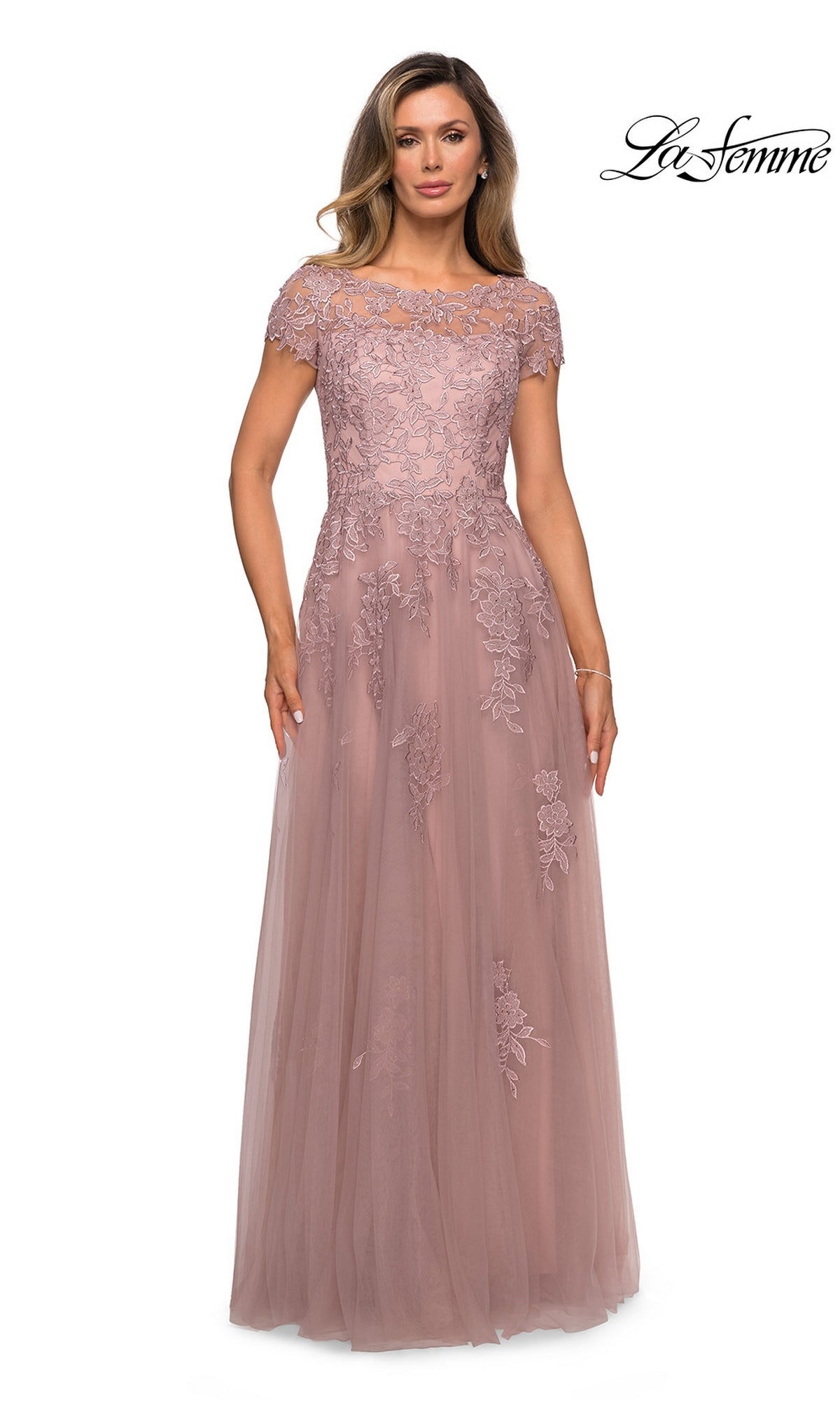 Woman in a floor-length mauve gown, La Femme 27920, featuring an A-line silhouette, lace, short sleeves, and floral embroidery. La Femme logo appears in the upper right.