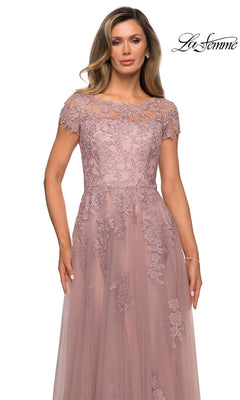 Woman wearing the Long Formal Dress: La Femme 27920, a mauve, short-sleeve, floor-length floral lace A-line dress with embroidery, stands against a white background.