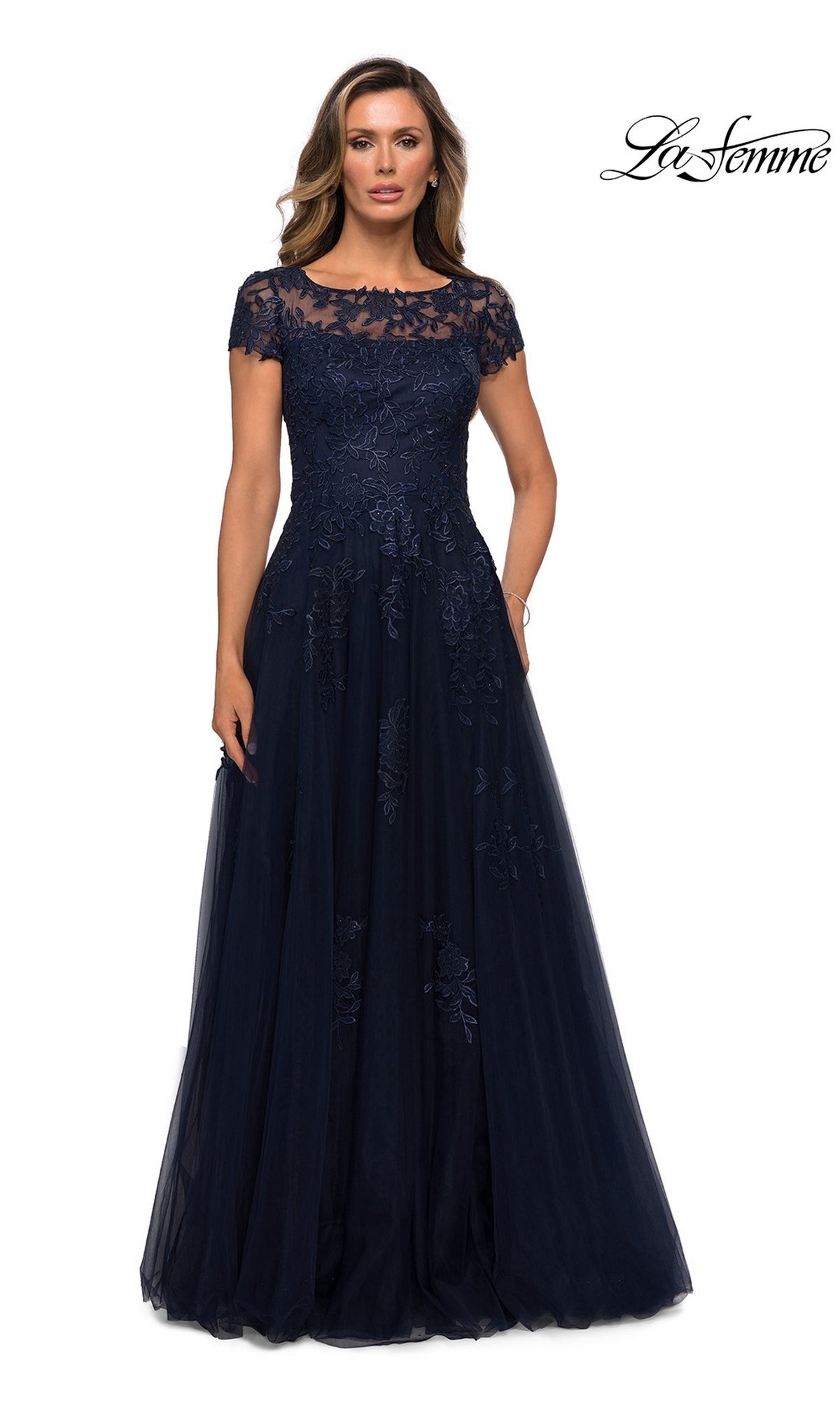 A woman wearing the Long Formal Dress: La Femme 27920 in navy, featuring an A-line silhouette and short sleeves, stands against a white background.