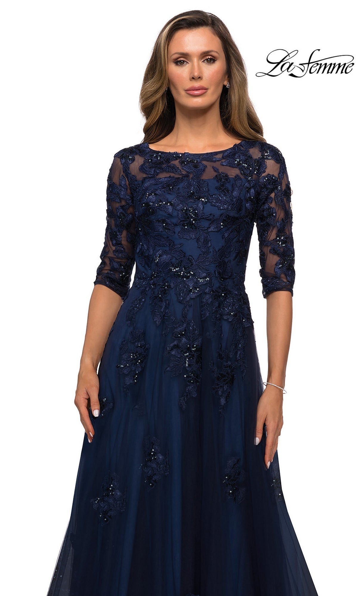 A navy blue, three-quarter sleeve modest Long Formal Dress: La Femme 27922 with a floral lace overlay and beaded accents on the bodice.
