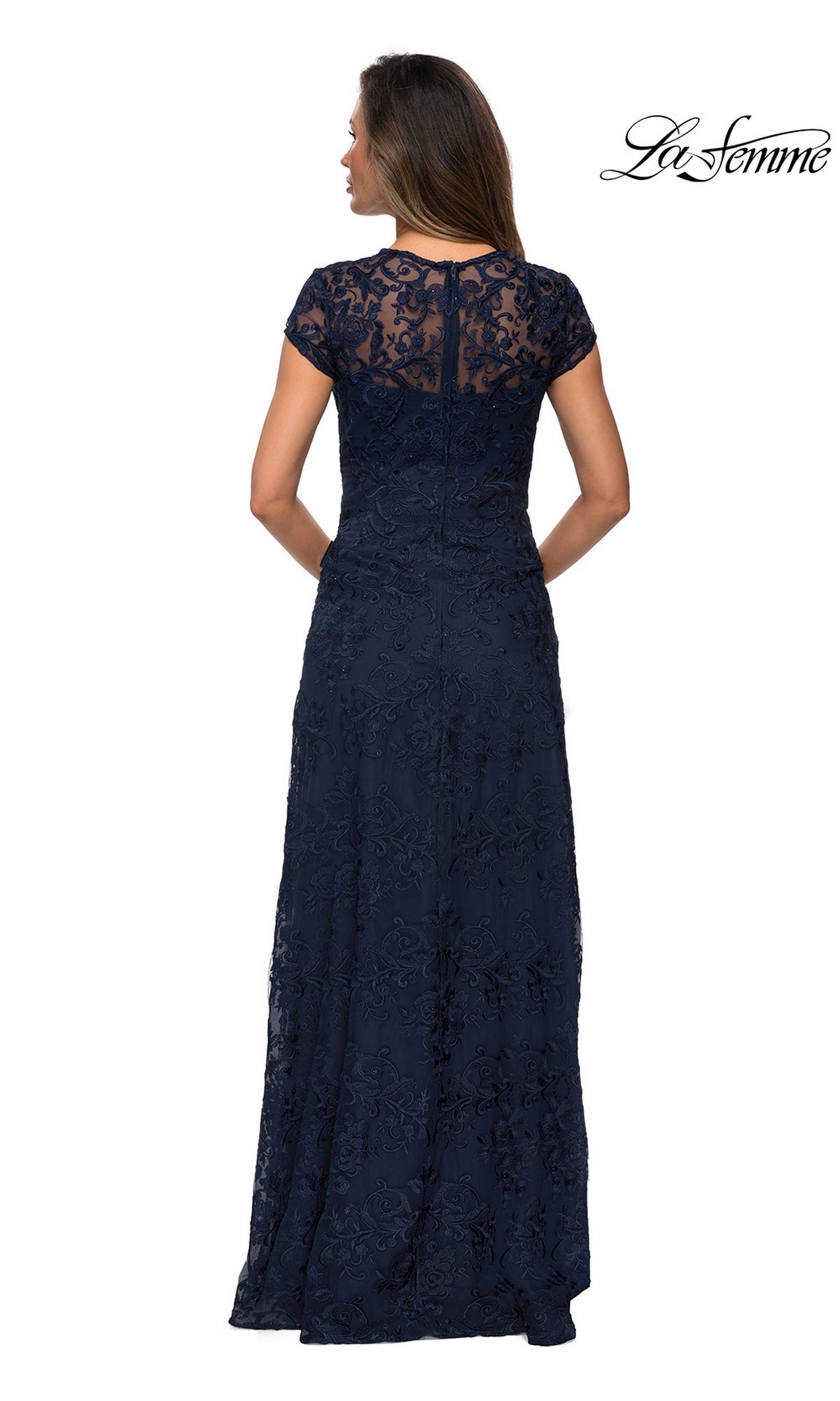Back view of a woman wearing a navy blue, short-sleeved floor-length La Femme 27951 gown with a floral lace overlay.