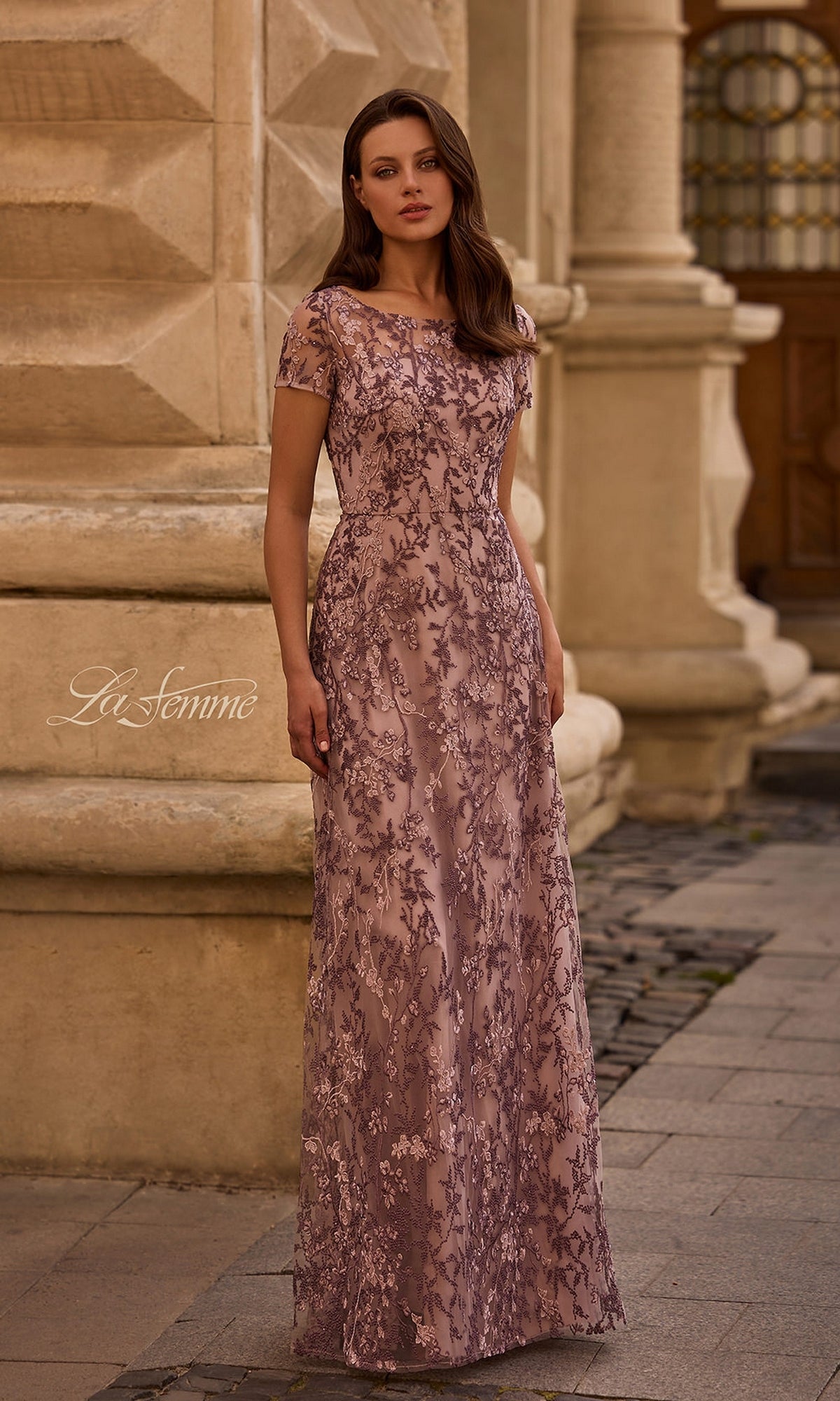 A woman stands outdoors in the Long Formal Dress: La Femme 27956 in Dusty Lilac, featuring floral beaded embellishments, perfect for a mother-of-the-bride.