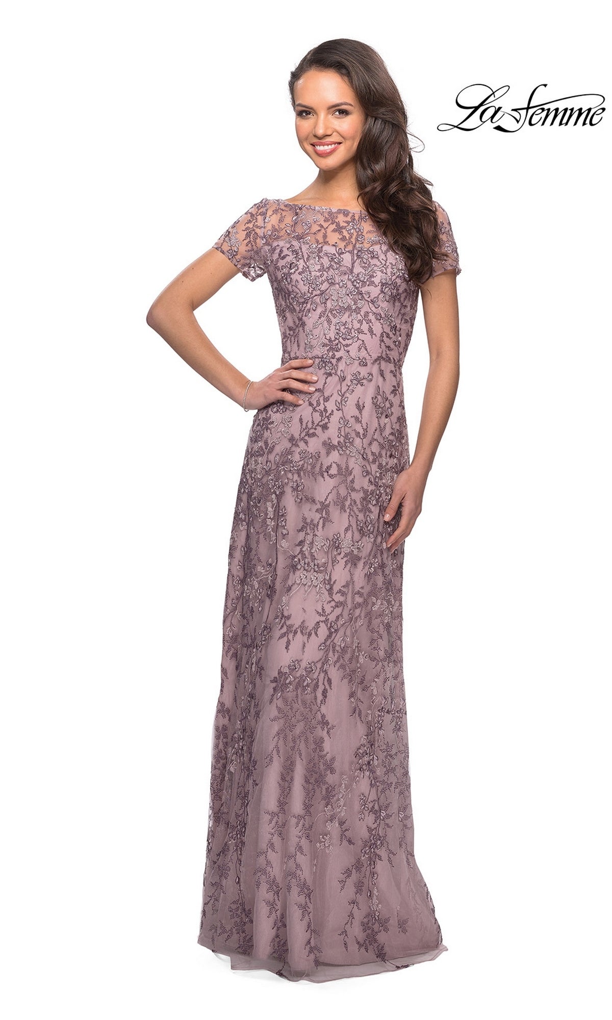 Woman wearing the mauve Long Formal Dress: La Femme 27956 with short sleeves, lace, and floral beading, standing with one hand on her hip. “La Femme” logo in top right.