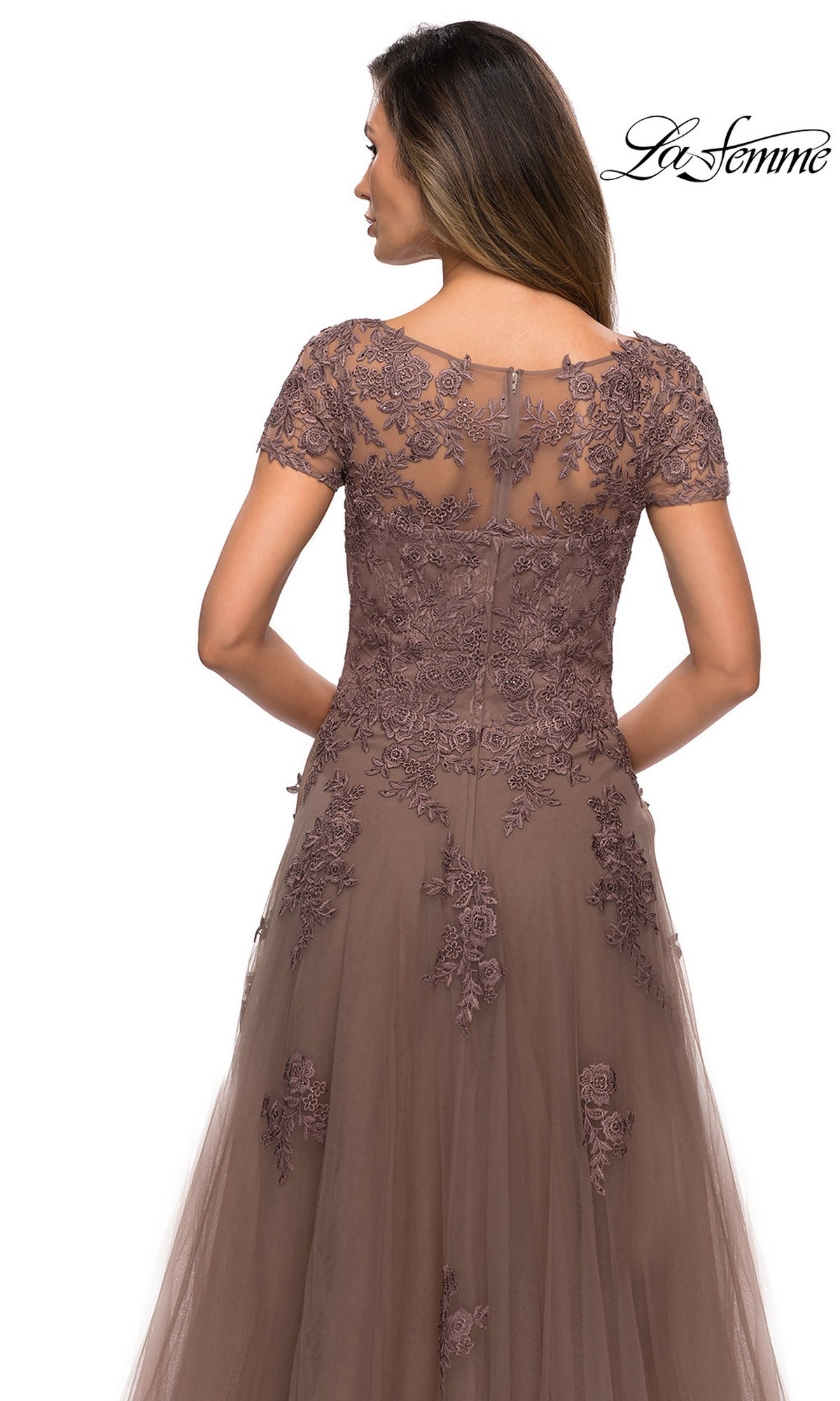 Back view of a woman in a Long Formal Dress: La Femme 27958, a cocoa floor-length gown with a sheer lace bodice, short sleeves, floral embroidery, and an A-line tulle skirt.