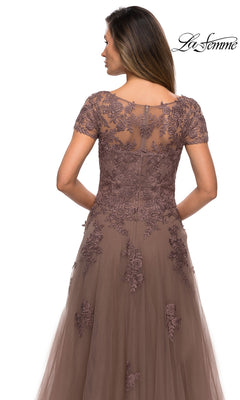 Back view of a woman in a Long Formal Dress: La Femme 27958, a cocoa floor-length gown with a sheer lace bodice, short sleeves, floral embroidery, and an A-line tulle skirt.
