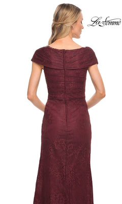 A woman is shown from the back wearing La Femme 27982, a floor-length short-sleeved burgundy lace mother of the bride gown with a fitted bodice and back zipper. The “La Femme” logo appears in the upper right corner.