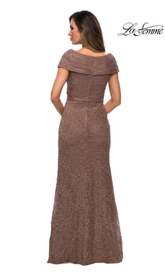 A woman wearing the Long Formal Dress: La Femme 27982, an off-the-shoulder, floor-length mauve lace mother of the bride gown, stands with her back to the camera. The “La Femme” logo appears in the top right corner.