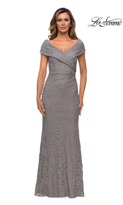 A woman stands wearing the Long Formal Dress: La Femme 27982—a floor-length, short-sleeve, light grey lace mother of the bride gown with a draped neckline. The La Femme brand logo appears in the top right corner.