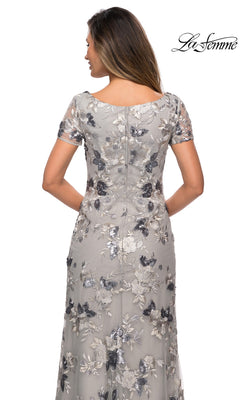 Back view of a woman wearing a La Femme 27991 floor-length silver formal dress with short sleeves and floral sequin embroidery.