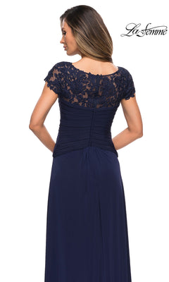 Woman in a navy blue Long Formal Dress: La Femme 28029 with lace cap sleeves, ruched bodice, and A-line skirt. The “La Femme” logo appears in the top right corner.