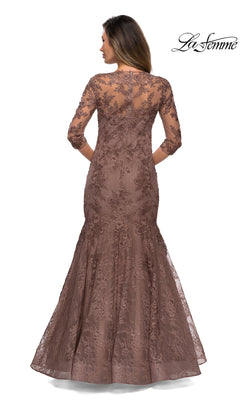 Woman in Long Formal Dress: La Femme 28033—a brown floral lace, floor-length gown with three-quarter sleeves and floral embroidery, shown from the back. “La Femme” logo top right.
