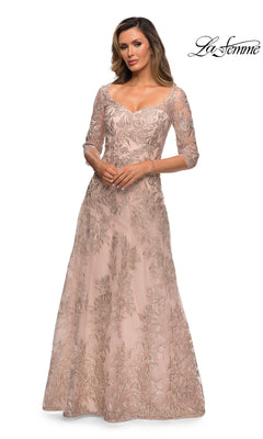 Woman wearing a champagne Long Formal Dress: La Femme 28053 featuring sheer three-quarter sleeves, floral embroidery, fitted bodice, and an elegant A-line skirt.