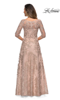 Woman wearing Long Formal Dress: La Femme 28053 in blush pink lace with three-quarter sleeves and embroidery, viewed from the back. “La Femme” logo in top right.