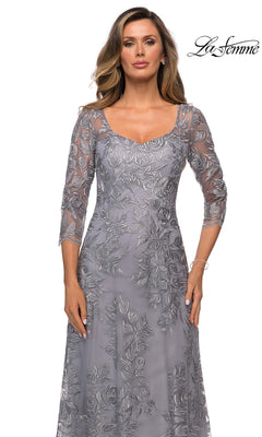 Woman in Long Formal Dress: La Femme 28053—silver-gray, floor-length lace with sheer three-quarter sleeves and floral embroidery; white background, “La Femme” logo top right.