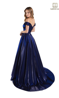 A woman stands gracefully against a white background in the Lucci Lu 28063 off-the-shoulder satin prom dress, featuring dark blue fabric and a flowing train.