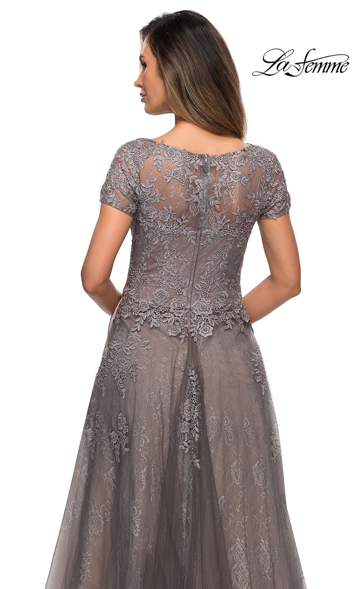 Back view of a woman in a Long Formal Dress: La Femme 28091, a floor-length platinum gown with a scalloped bodice and gray lace appliques.
