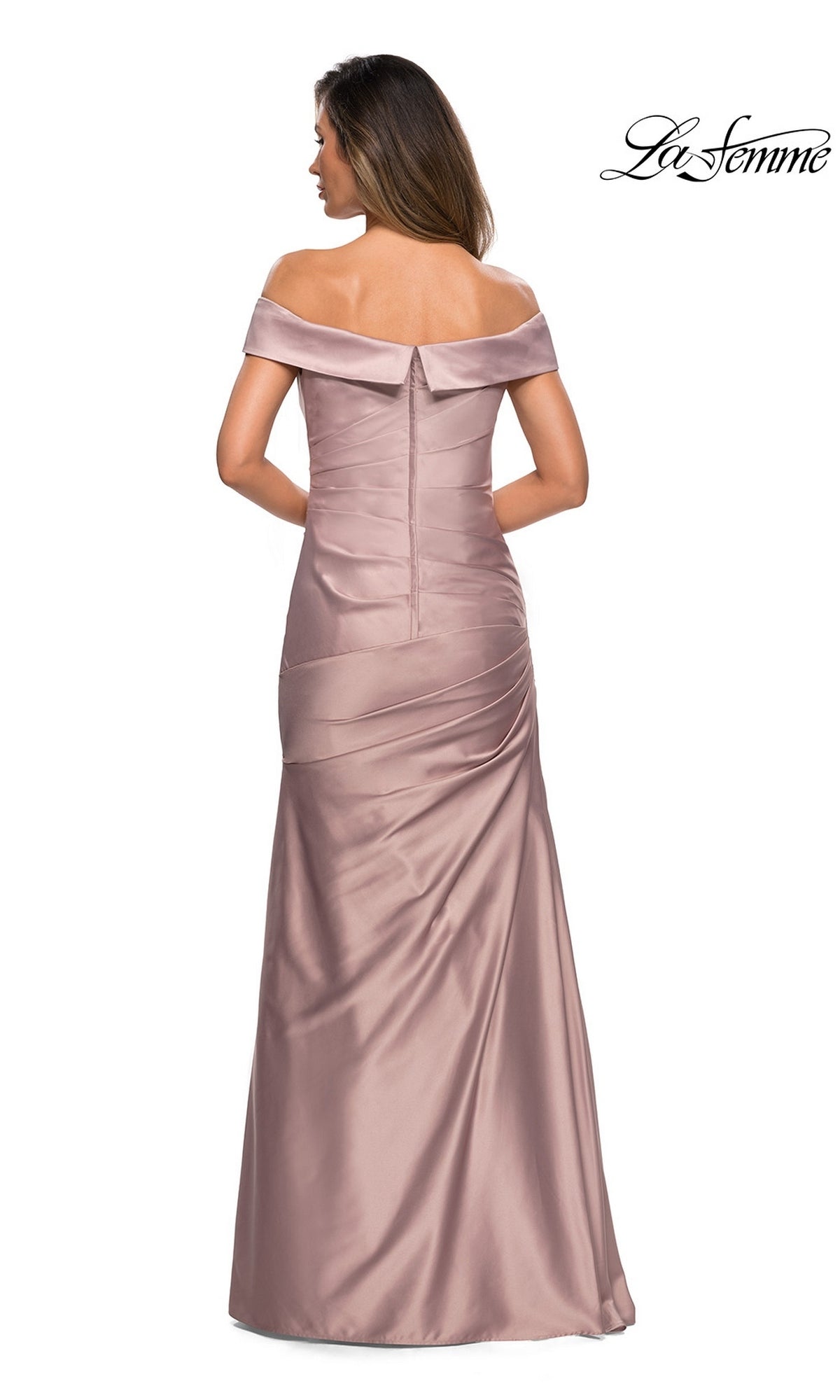 A woman stands facing away, showcasing the back zipper and ruched detailing of the La Femme 28103 long formal dress. This elegant mauve, floor-length gown features a satin finish and an off-the-shoulder neckline—perfect for a sophisticated mother-of-the-bride look. “La Femme” logo appears in the top right corner.