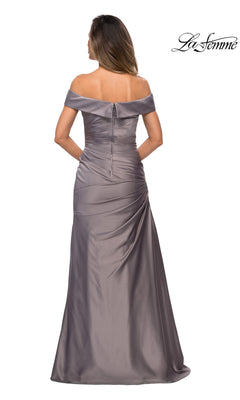 A woman is shown from the back wearing La Femme 28103, a long formal silver satin gown featuring an off-the-shoulder neckline, floor-length design, delicate ruching detail, and a visible zipper. The “La Femme” logo appears in the top right corner.
