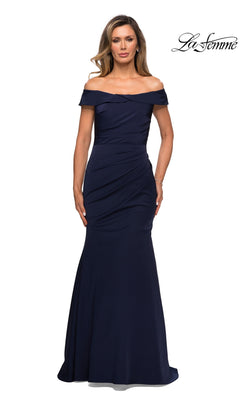 Woman in a navy, fitted satin Long Formal Dress: La Femme 28110 with ruched details and trumpet silhouette, poses against a white background. “La Femme” logo in upper right.