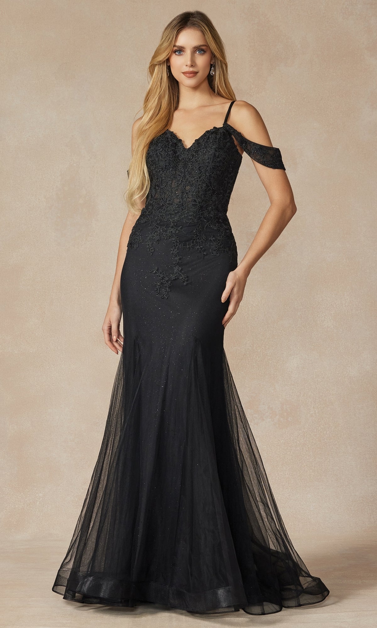 A woman wearing the Long Glitter Mermaid Prom Dress: Juliet 281, a floor-length black gown with lace, sheer detailing, and an off-the-shoulder mermaid silhouette, stands against a neutral background.