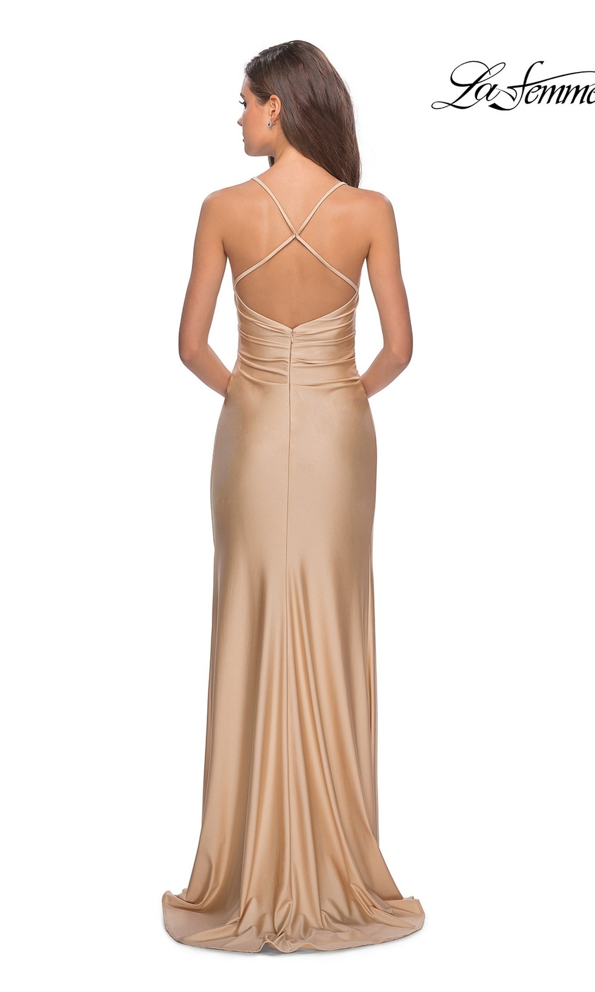 A woman models the La Femme Open-Back Long V-Neck Prom Dress 28206 in gold satin, featuring thin crisscross straps, an open back, and waist ruching, as she stands against a white background.