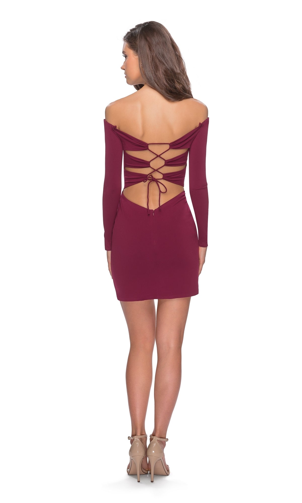 Woman in the La Femme Off-Shoulder Long Sleeve Hoco Dress 28212, featuring an open back with crisscross lace-up detail, stands in neutral heels facing away from the camera—a chic semi-formal party look.