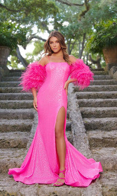 A woman stands on stone steps outdoors in the Long Formal Dress 28287 by Ava Presley, a sequin mermaid gown with a thigh-high slit and feather sleeves. Lush trees and plants complete her glamorous evening look.