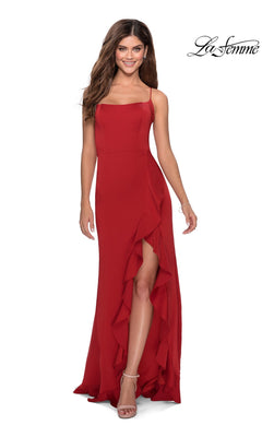 A woman poses and smiles against a white background in the La Femme Side-Ruffle Long Prom Dress 28294, a sleeveless red gown with spaghetti straps, a ruffled slit, and an elegant open-back formal design.
