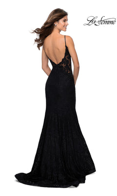 A woman models the La Femme Backless Long Lace Prom Dress 28355, featuring thin straps, a low open back, floral lace details, a slight train, and a mermaid skirt—an elegant black gown ideal for prom or formal evenings.